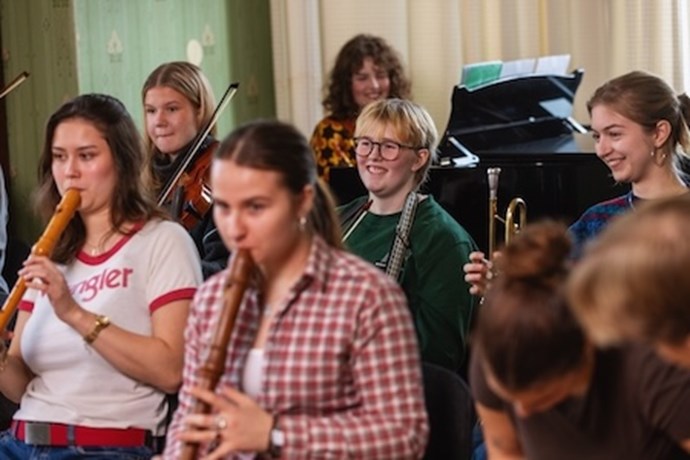 Ungdomar som spelar olika instrument.